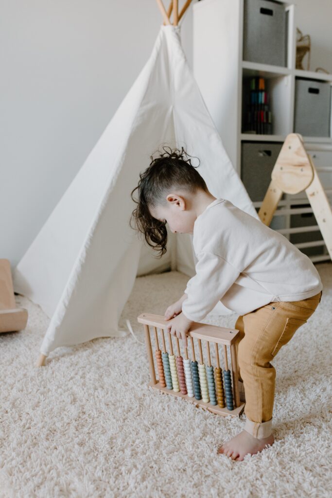 a boy plays with his toy on the carpet