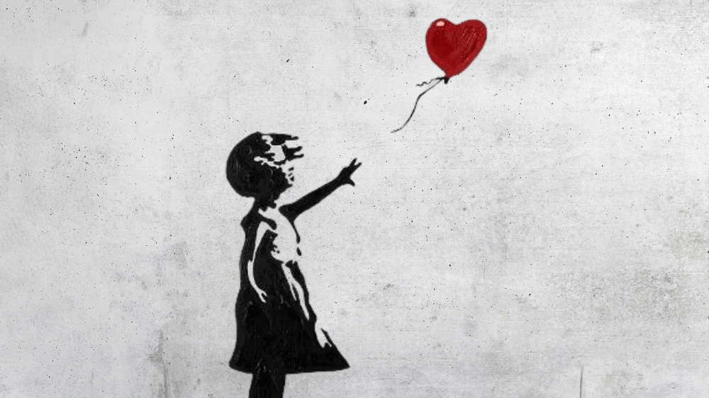 An image of a girl reaching out a heart-shaped balloon